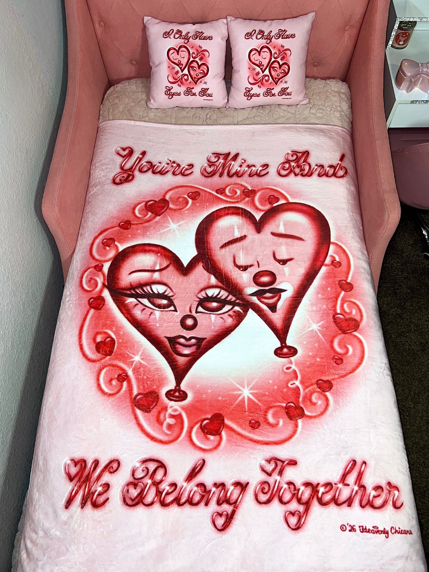 Bedding set with heart design and text 'You're Mine And We Belong Together' on a pink bed.