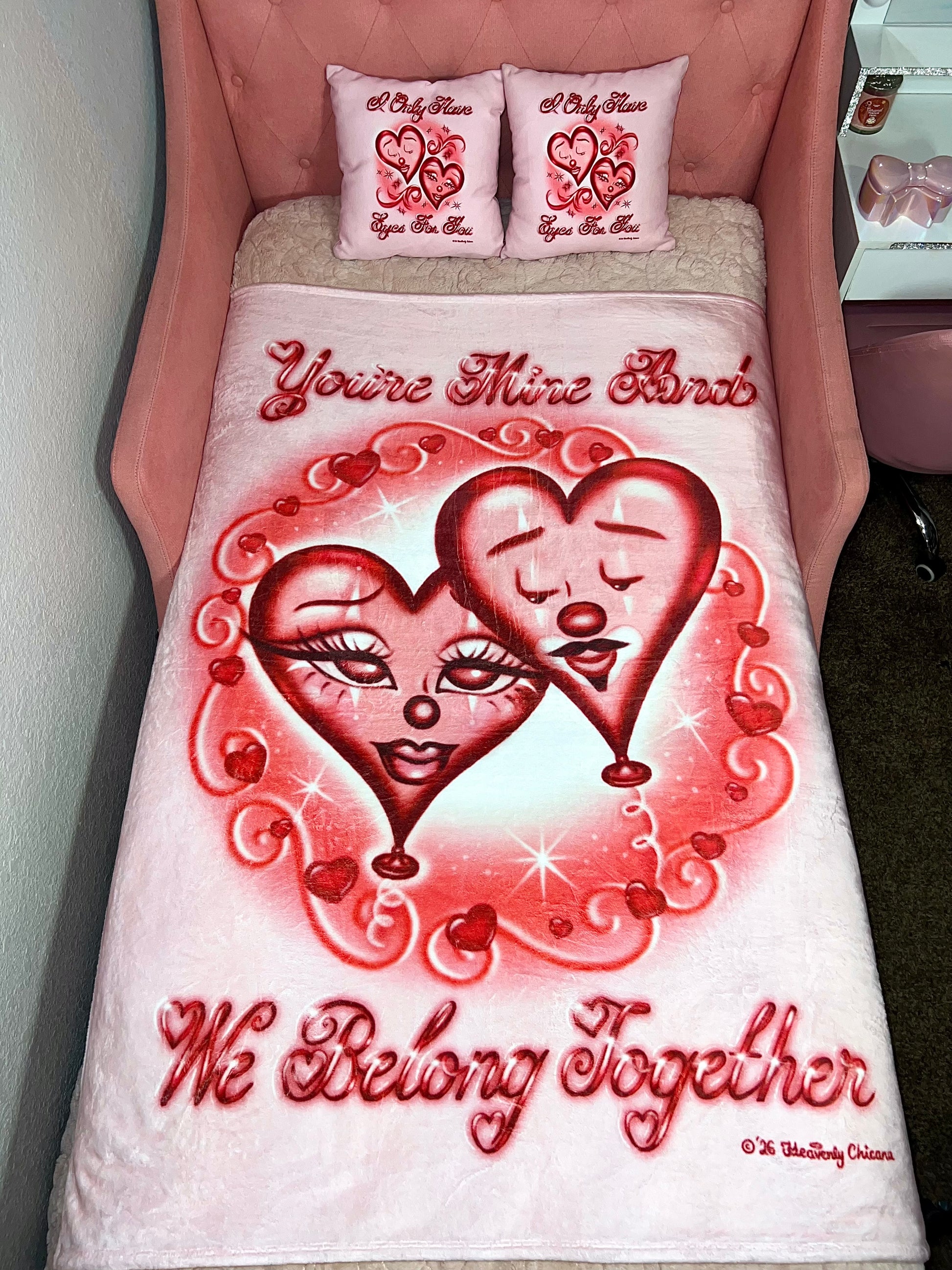Bedding set with heart design and text 'You're Mine And We Belong Together' on a pink bed.